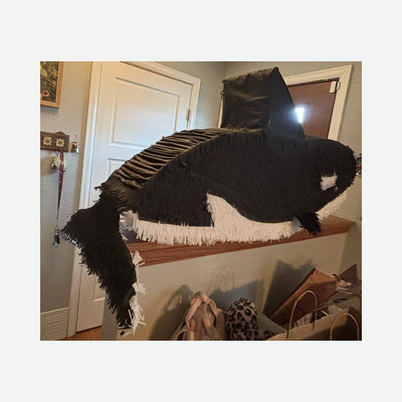 An orca piñata in black and white with a tall dorsal fin